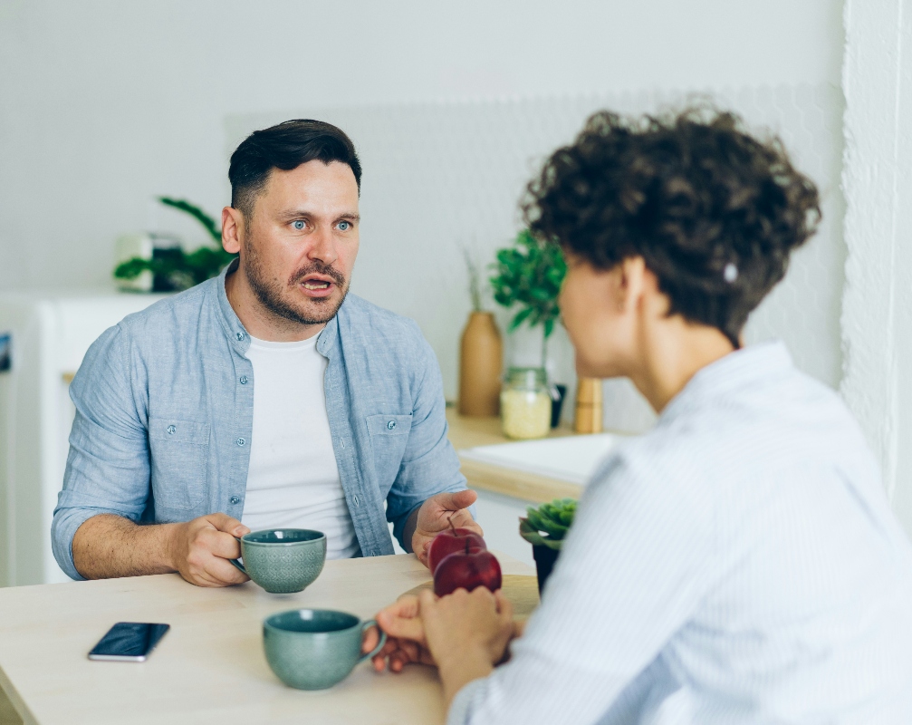 Man and woman arguing at table