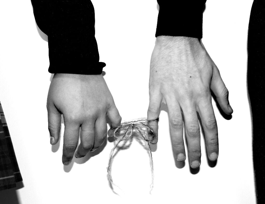 Man and woman fingers tied together with string